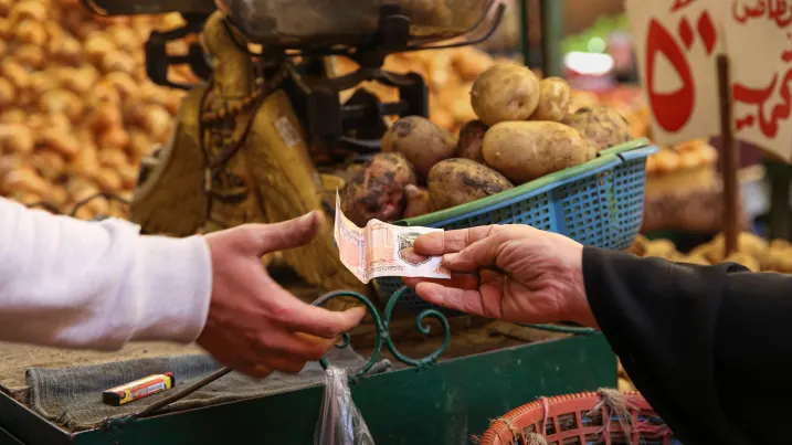 A customer hands over an Egyptian pound banknote for a purchase at Al-Monira food market in the Imbaba district of Giza, Egypt, in January 2023. Egypt is one of many countries where consumers are struggling with sharply higher prices, highlighted by the World Economic Forum as the greatest global risk in 2023.